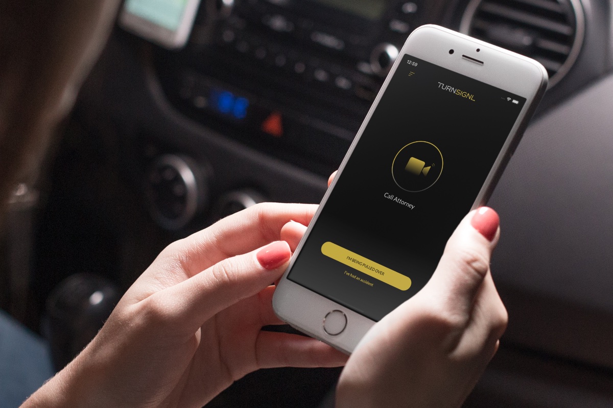 Woman inside car holding iPhone using the TurnSignl app